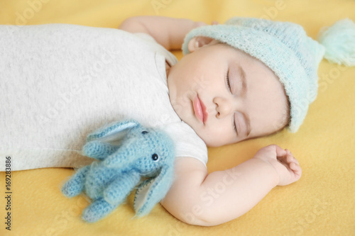 Cute little baby sleeping with toy on bed © Africa Studio