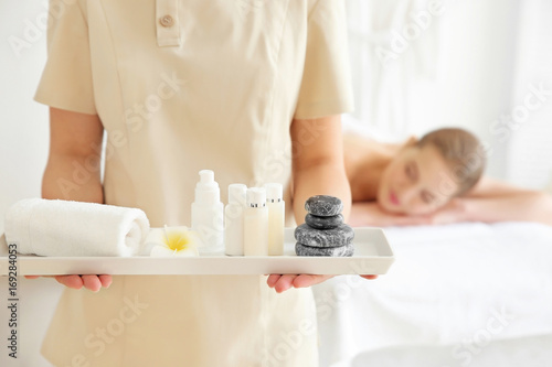 Masseuse holding tray with cosmetics in the spa salon