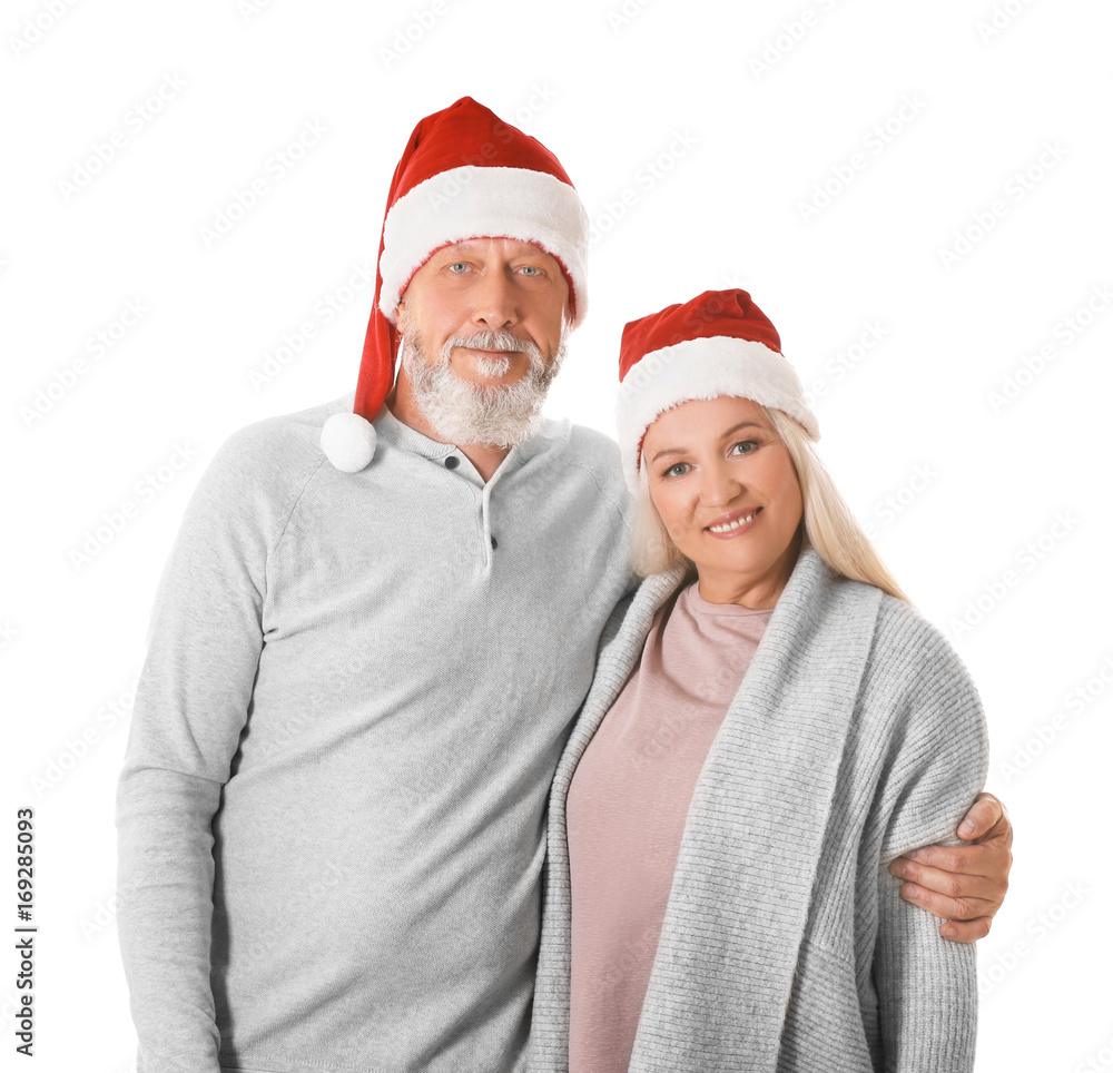 Happy senior couple with Christmas hats on white background Happy senior couple with Christmas hats on white background