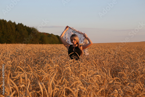 Молодая девушка с платком на пшеничном поле
