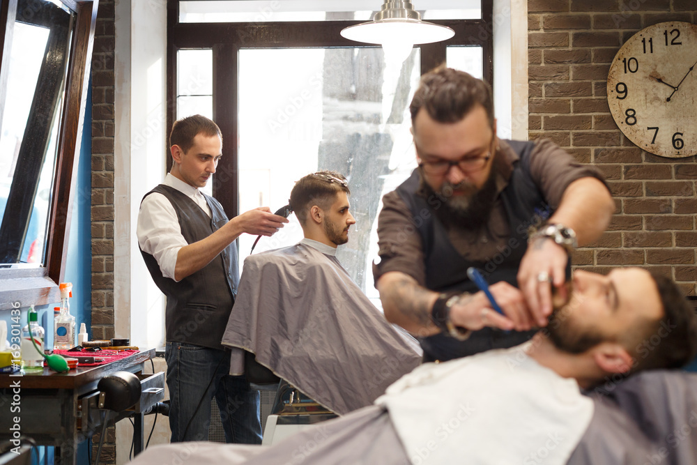 Man getting haircut by hairstylist at barbershop Man getting haircut by hairstylist at barbershop