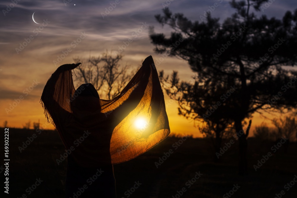 Back view of muslim woman praying .Praying time . Glowing sunset . Ramadan Kareem . Ramadan background . Arab night