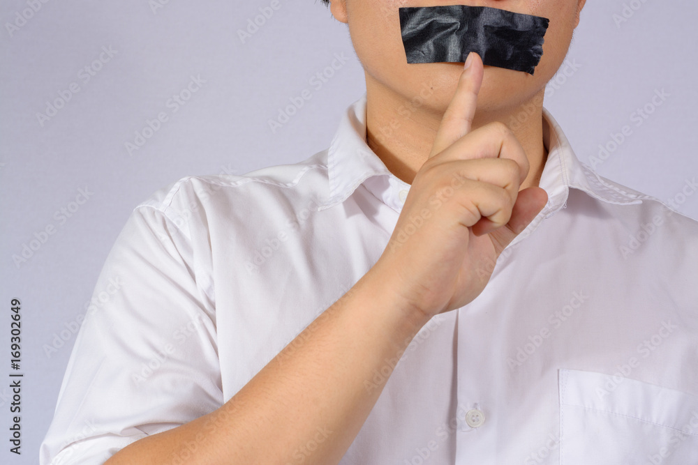 Young Man with black duct tape over his mouth on grey background.
