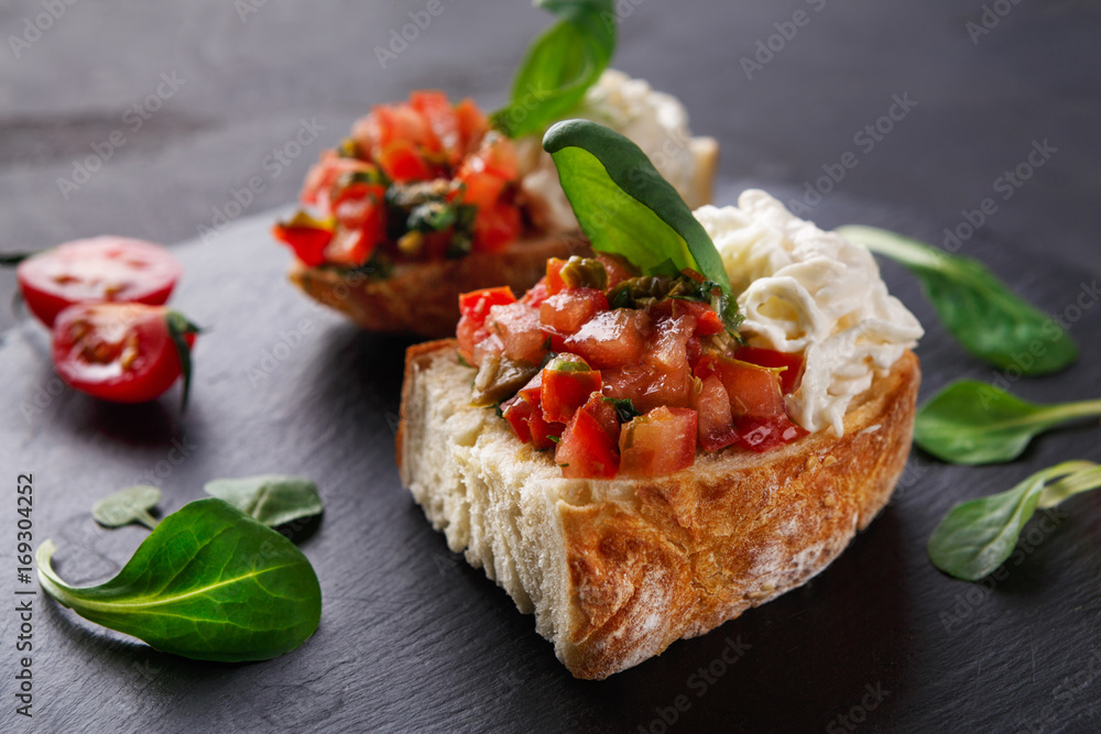 Bruschetta with cheese and vegetables on black background