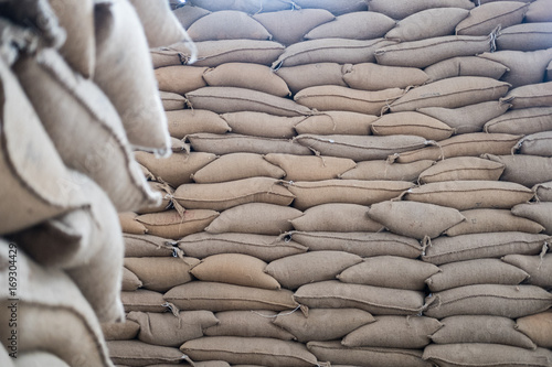 hemp sacks containing coffee bean in warehouse. stacked sacks in storehouse.