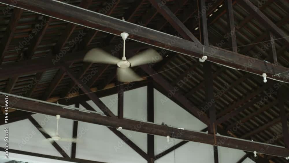 Static shot of three ventilators used as air conditioners for cooling the air in industrial building during hot summer days, fans placed on metal with wood ceiling of factory or creative space Static shot of three ventilators used as air conditioners for cooling the air in industrial building during hot summer days, fans placed on metal with wood ceiling of factory or creative space