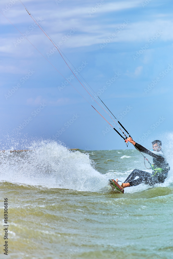 Obraz premium Kitesurfing on waves at sea in summer.