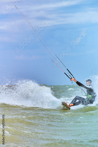 Kitesurfing on waves at sea in summer. © trek6500