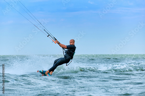 Kitesurfing on waves at sea in summer.