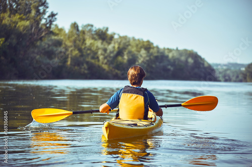 A canoe trip along the river along the forest in summer.
