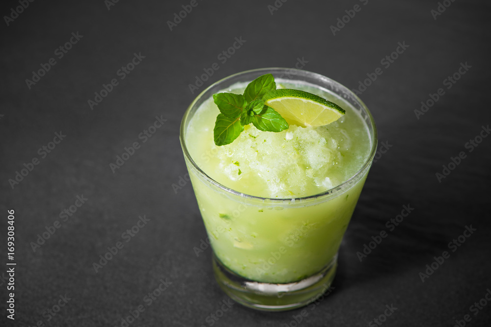 Cocktail juice with lime, mint and ice. Bar drink accessories on black table background. Cocktail juice with lime, mint and ice. Bar drink accessories on black table background.