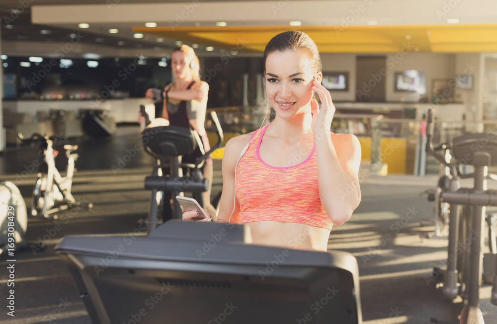 Young woman in gym run on treadmill