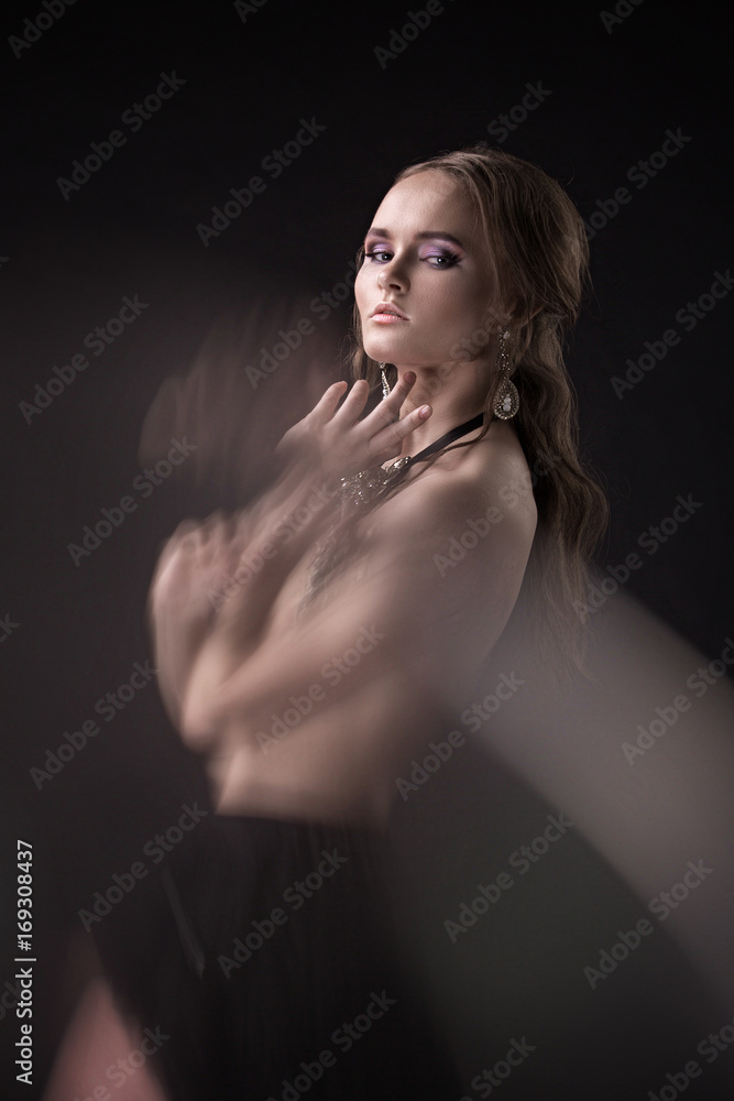 Fototapeta premium Portrait of a nude, stylish, beautiful girl, model with a beautiful glow in the studio. Nude, potret, studio, style, beauty.