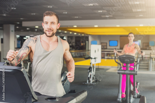 Young man in gym run on treadmill