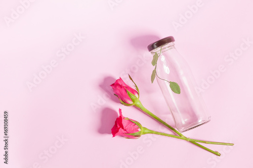 Empty bottle and rose On the pink background 