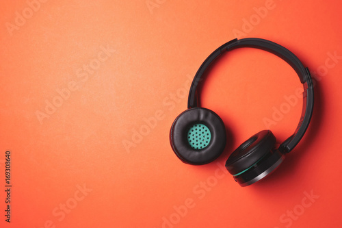 Modern headphones on a orange background. Free space for text