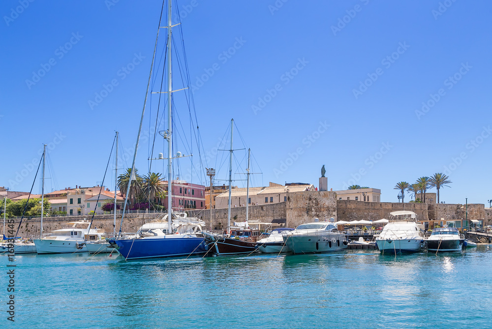Alghero, Sardinia, Italy. Boats and yachts in the port against the walls of the fortress