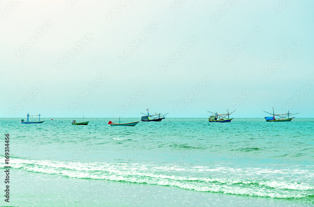 The view of sand beach and sea wave on afternoon, Beautiful of beach and sea with fishing boat in the sea.