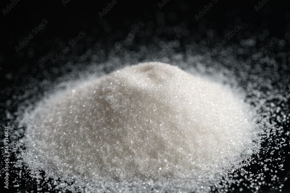 Fototapeta white sugar heap on black background closeup photo