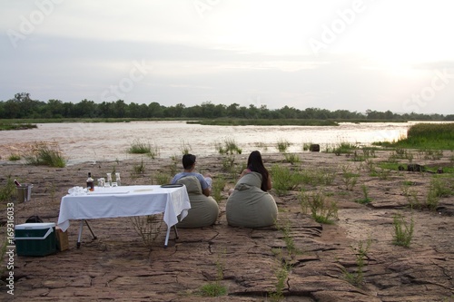 Indian couple at sunset next to a river in Selous Game Reserve, Tanzania photo