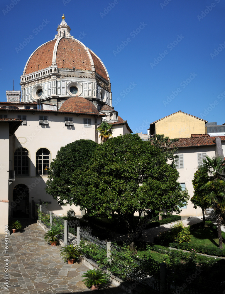 Garden in the centre of Florence and the Cathedral of Santa Maria del Fiore (Duomo di Firenze) on background with beautiful blue sky. Italy.