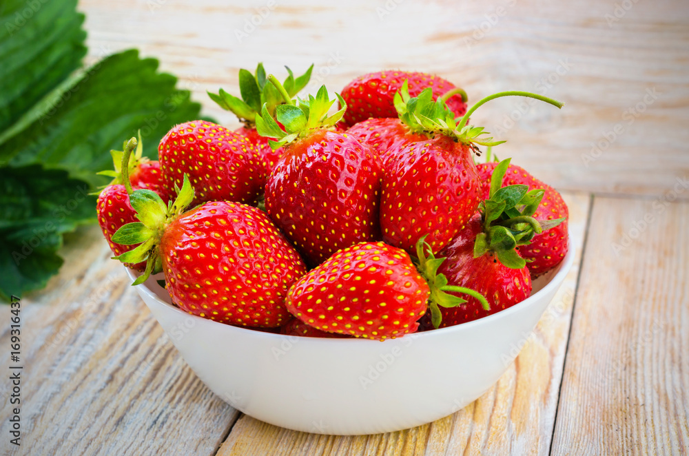 Red strawberries on a light wooden table. Red strawberries on a light wooden table.