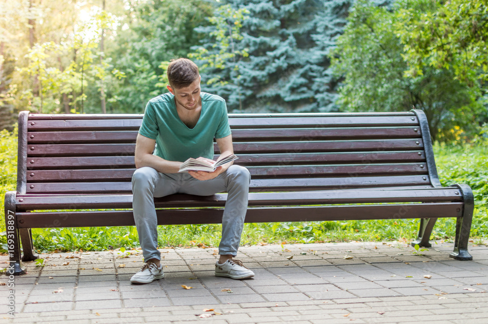 Young man reading book in the park Young man reading book in the park