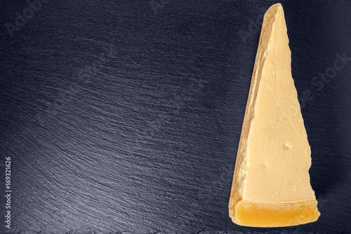 top view of single tasty fresh yellow big segment piece parm on stone slate background, close up