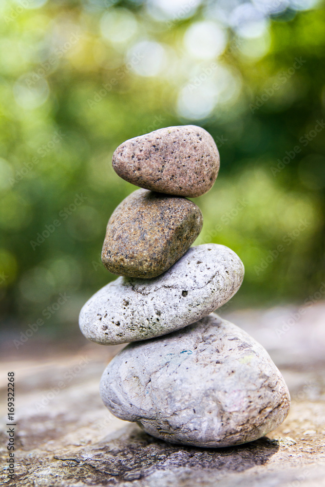 Smooth stones balancing on one another in a garden setting Smooth stones balancing on one another in a garden setting