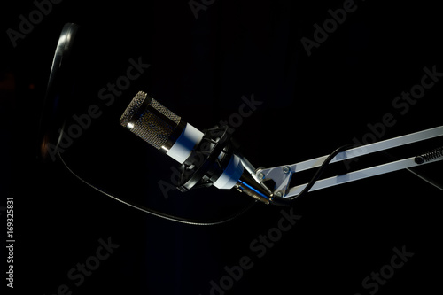 Professional condenser studio microphone on the black background