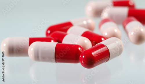 Heap of red and pink antibiotics capsule photo