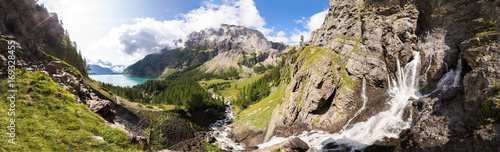 Fényképezés Panorama of torrent stream, lake, green valley in Alps mountains
