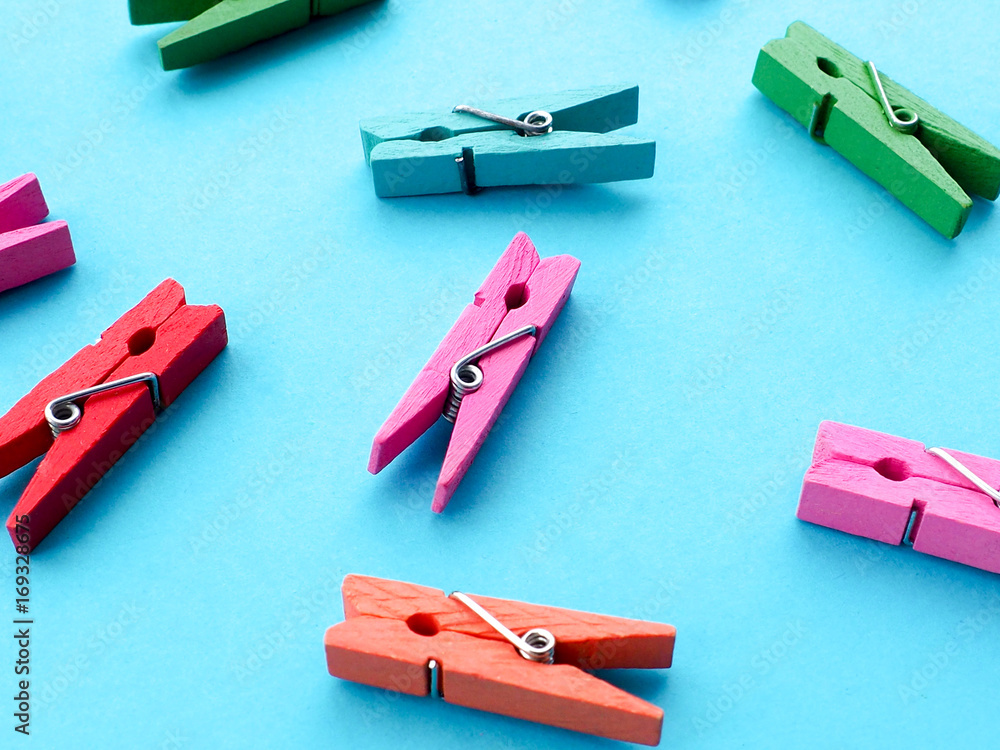 many colored clothespins on a blue background, as a substrate, pin; clothes peg many colored clothespins on a blue background, as a substrate, pin; clothes peg