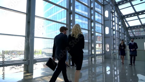 Business people walking in modern glass office building