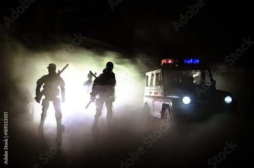 Anti-riot police give signal to be ready. Government power concept. Police in action. Smoke on a dark background with lights. Blue red flashing sirens. Dictatorship power. photo