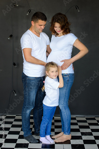Happy pregnant family with little girl having fun