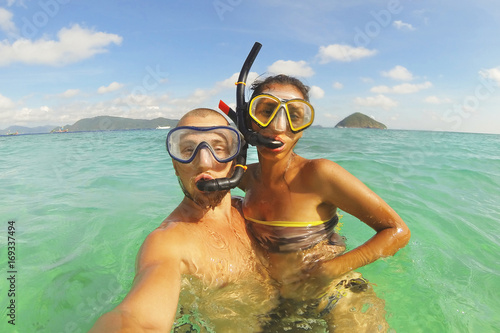 Young Mixed Race Couple Making Selfie Photo Using Waterproof Camera in Clear Ocean after Snorkeling. Phuket, Thailand.