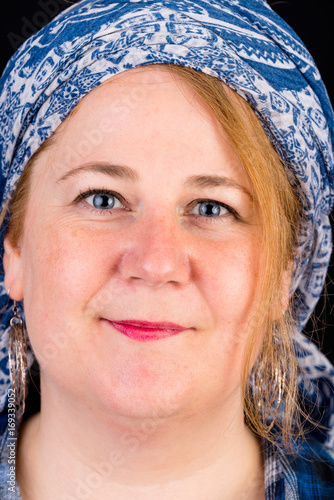 Portrait of a attractive european light overweighted red haired female with blue lumberjack shirt - view on head, studio shot in fron of black background