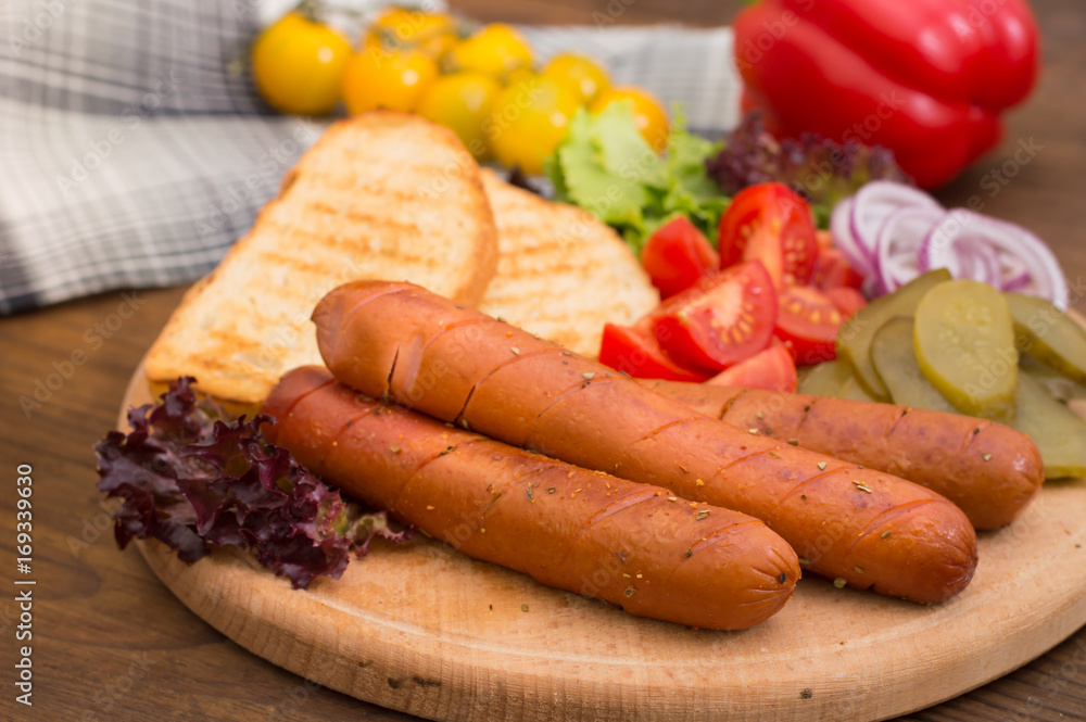 Food set for hot dog, sausage, canned cucumbers, lettuce leaves, tomatoes, onions, croutons on the wooden background. Close-up. Top view Food set for hot dog, sausage, canned cucumbers, lettuce leaves, tomatoes, onions, croutons on the wooden background. Close-up. Top view