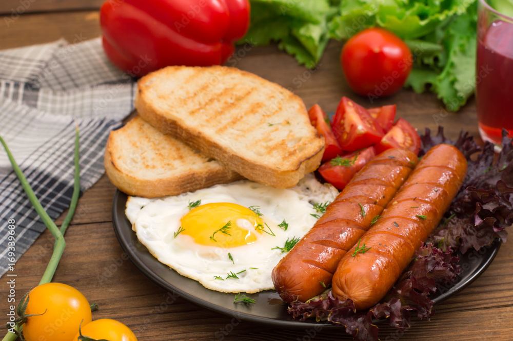 English breakfast - toast, egg, sausages and vegetables salad. Wooden rustic background. Close-up. Top view English breakfast - toast, egg, sausages and vegetables salad. Wooden rustic background. Close-up. Top view