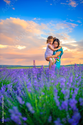 mother with the beloved daughter walk in the lavender field on a sunset