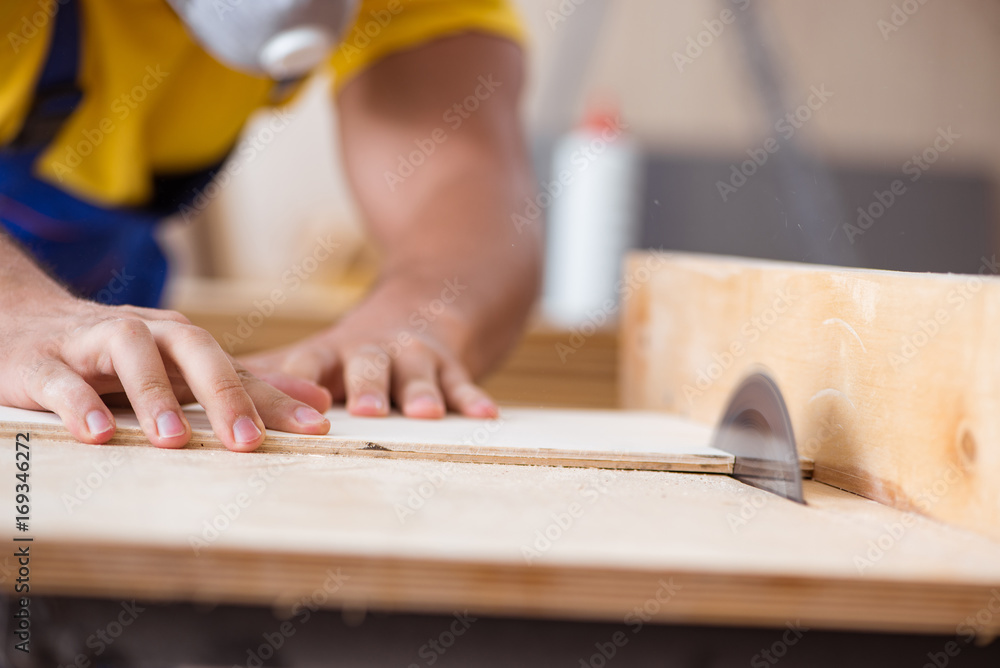 Young repairman carpenter working with a circular saw Young repairman carpenter working with a circular saw