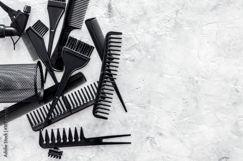 black combs, brushes for hairdresser work on stone desk background top view mock up