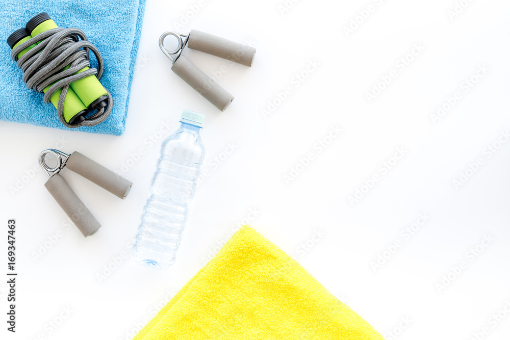 Equipment for fitness. Jump rope and expander on white background top view copyspace Equipment for fitness. Jump rope and expander on white background top view copyspace