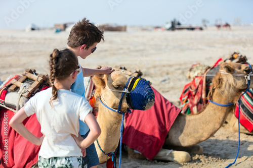 Kids with camels at desert