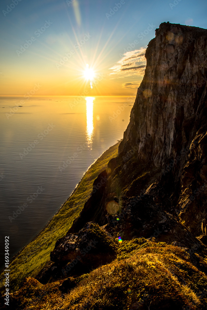 Fjord mountain midnight sun setting over water