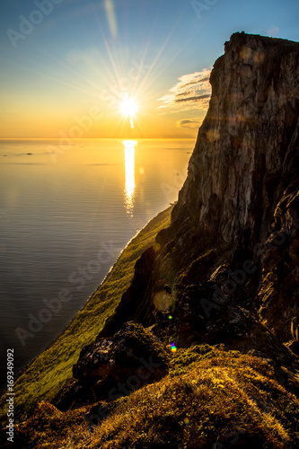 Obraz na płótnie Fjord mountain midnight sun setting over water w salonie
