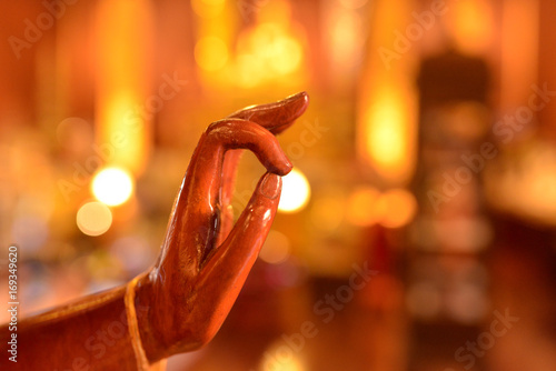 hand of buddha statue with yellow light in the temple
