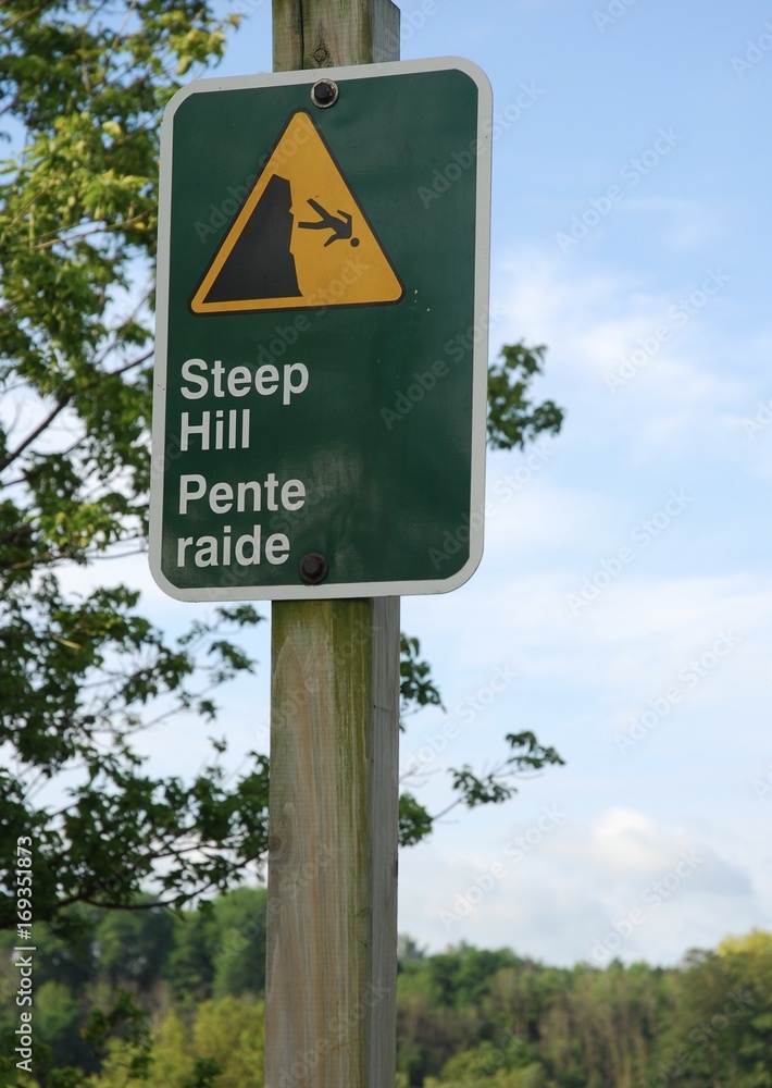 Steep hill sign warning in park on a summer morning