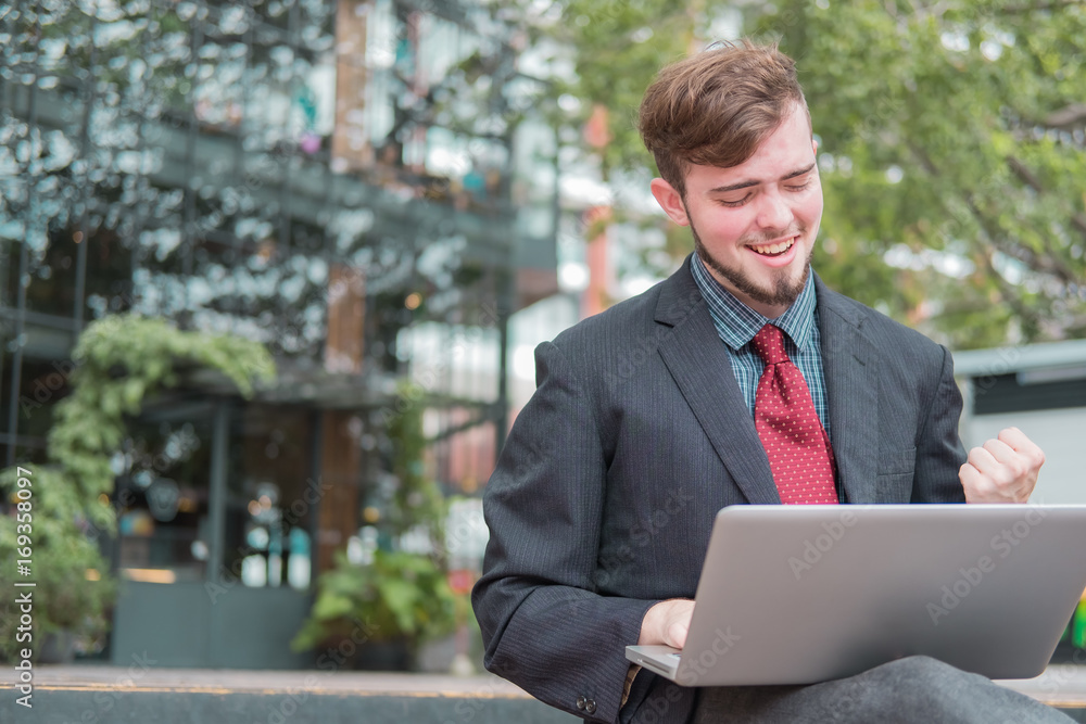 Looking for direction and inspiration, Portrait of happy young businessman sitting with laptop Looking for direction and inspiration, Portrait of happy young businessman sitting with laptop